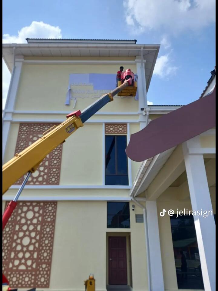 Bakul skylift SOHHO di sebelah papan tanda bangunan