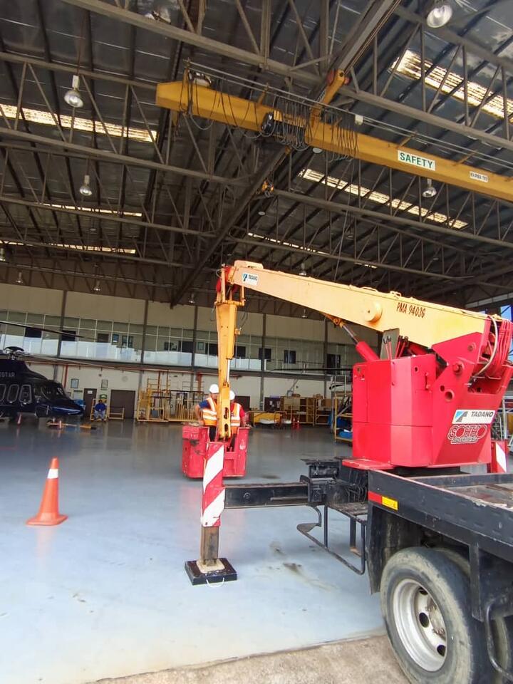 Kru di bakul skylift di dalam hangar
