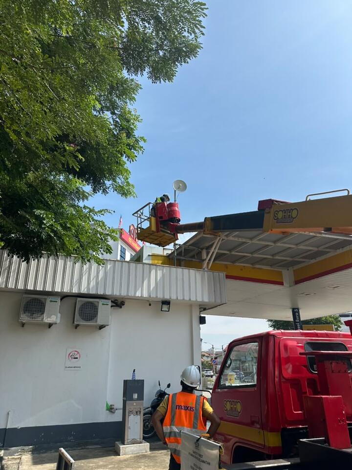 Pekerja di bakul skylift memasang antena