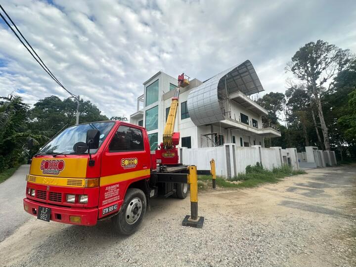 Lori skylift Isuzu SOHHO di rumah dalam pembinaan